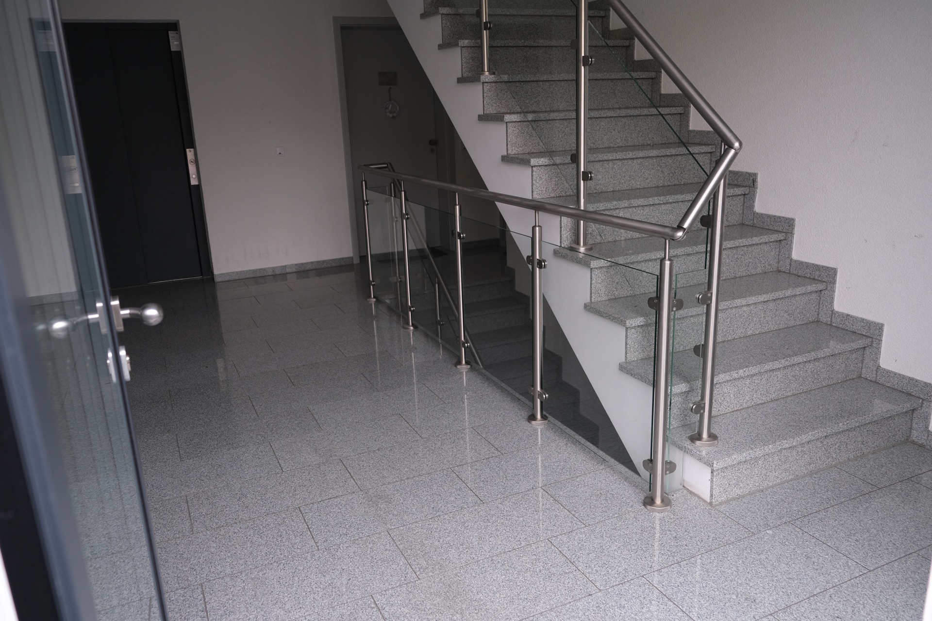 Reale geradläufige Treppe mit Edelstahlpfosten, rundem Handlauf und Glasfüllung